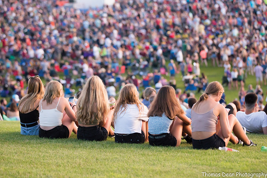 Crowd sitting on a hill watching the Lakefront Music Fest.