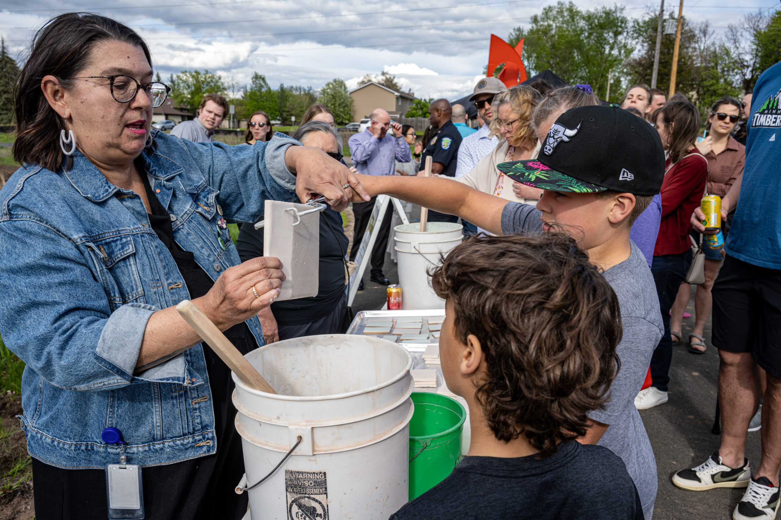 Community members glaze tiles that will be used in the new Eagan Art House building.