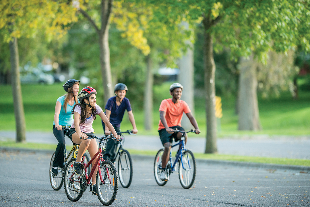 Young adults out riding bikes.