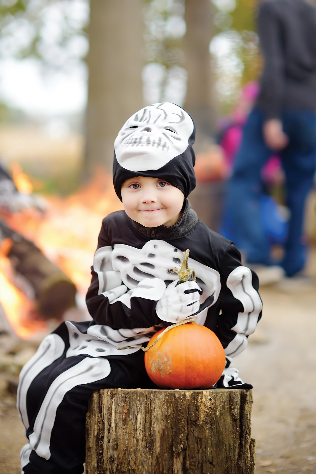 Little boy in scary skeleton costume at halloween celebrations party in forest. Halloween - traditional american holiday.