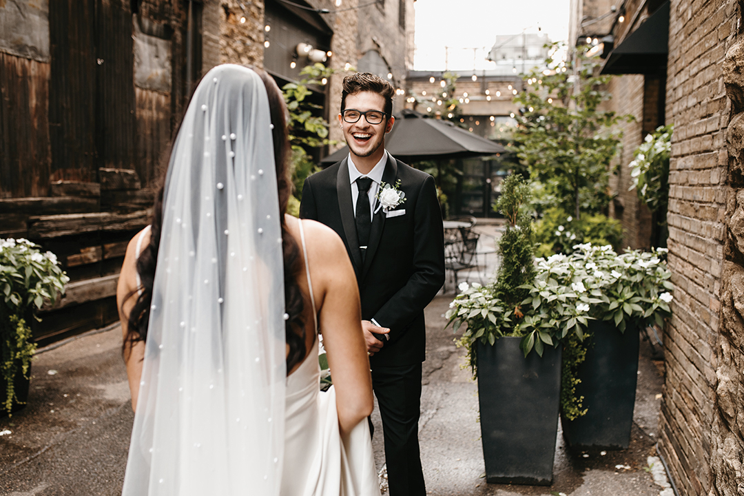 The groom’s suit, from St. Paul’s Milbern Clothing Co., included a sophisticated black jacket with satin lapels and a textured floral tie. His look was complete with Calvin Klein Brodie Oxford shoes and a gift from his bride: custom cufflinks adorned with the images of their pets.