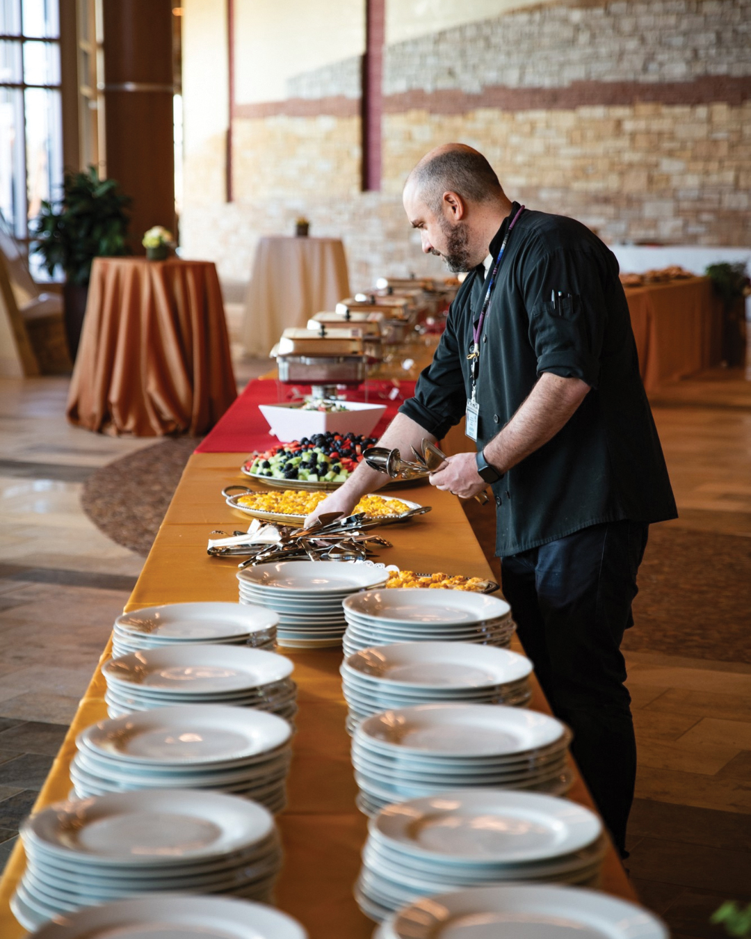 Senior manager of Shakopee Mdewakanton Sioux Community food services Andrew Basil sets up a buffet at Hoċokata Ti.
