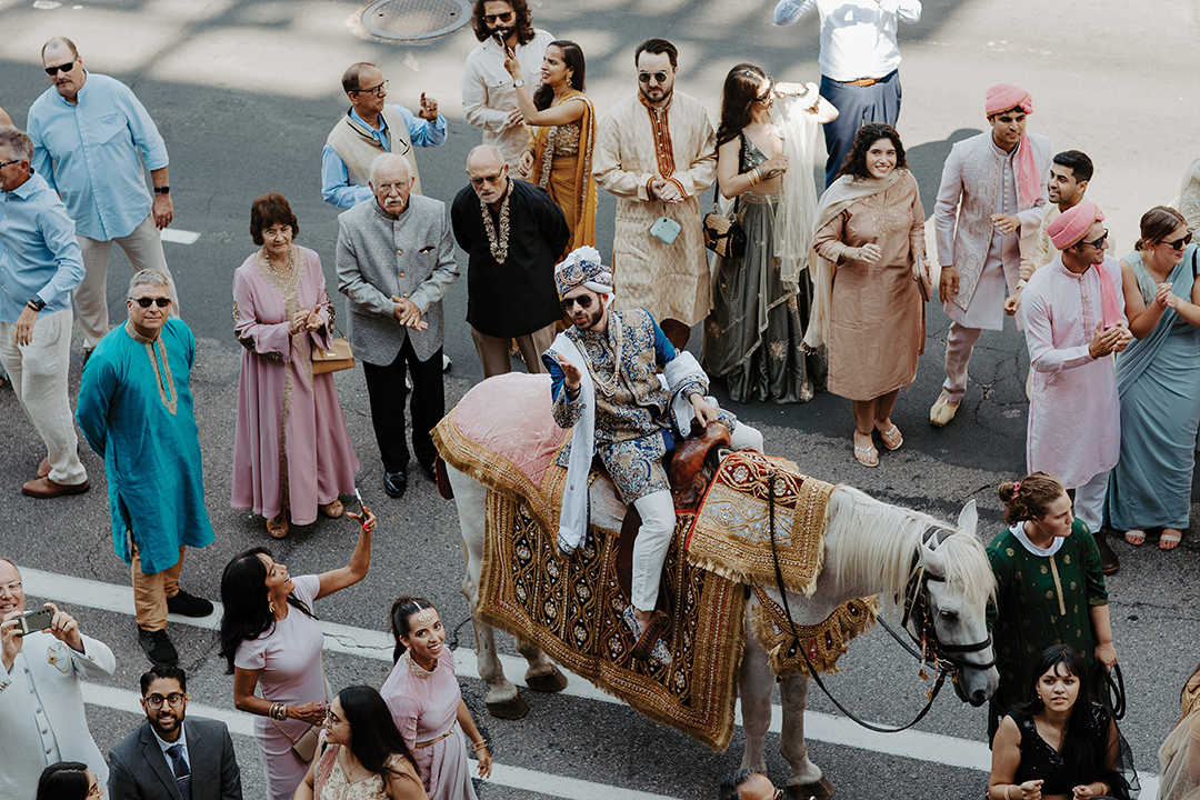 Shane Will makes a grand entrance on a white horse for the baraat. The streets outside the Mosaic Venue in Minneapolis were blocked off for the procession.