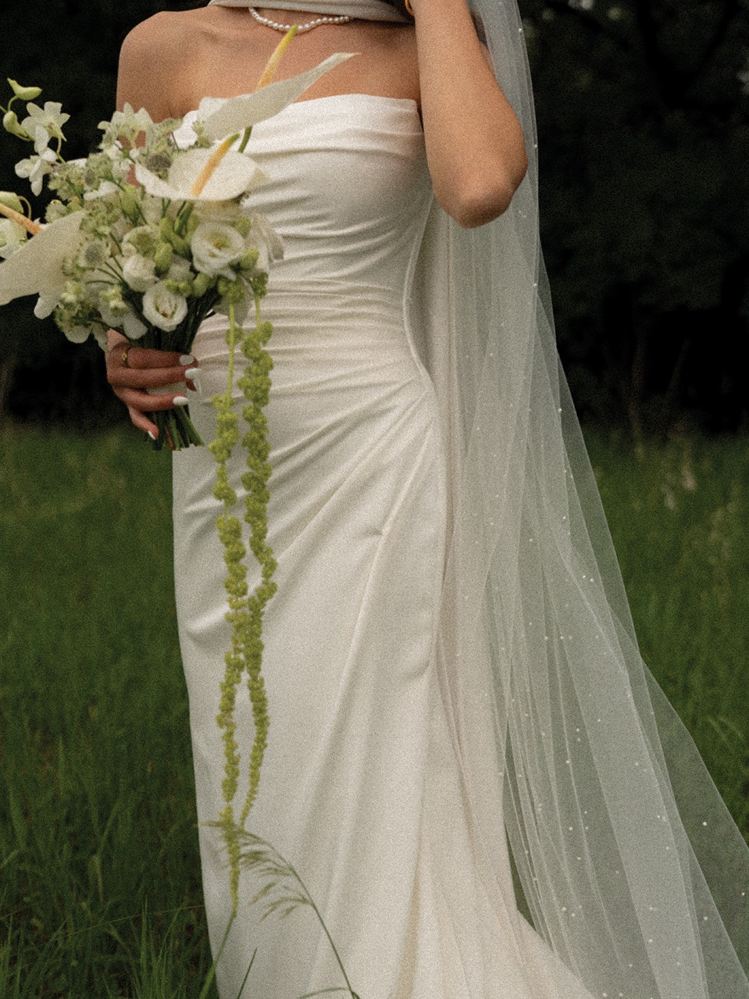 Alayna Lotto opted for a classic wedding gown with a long scarf and long veil that incorporated her signature pearls.