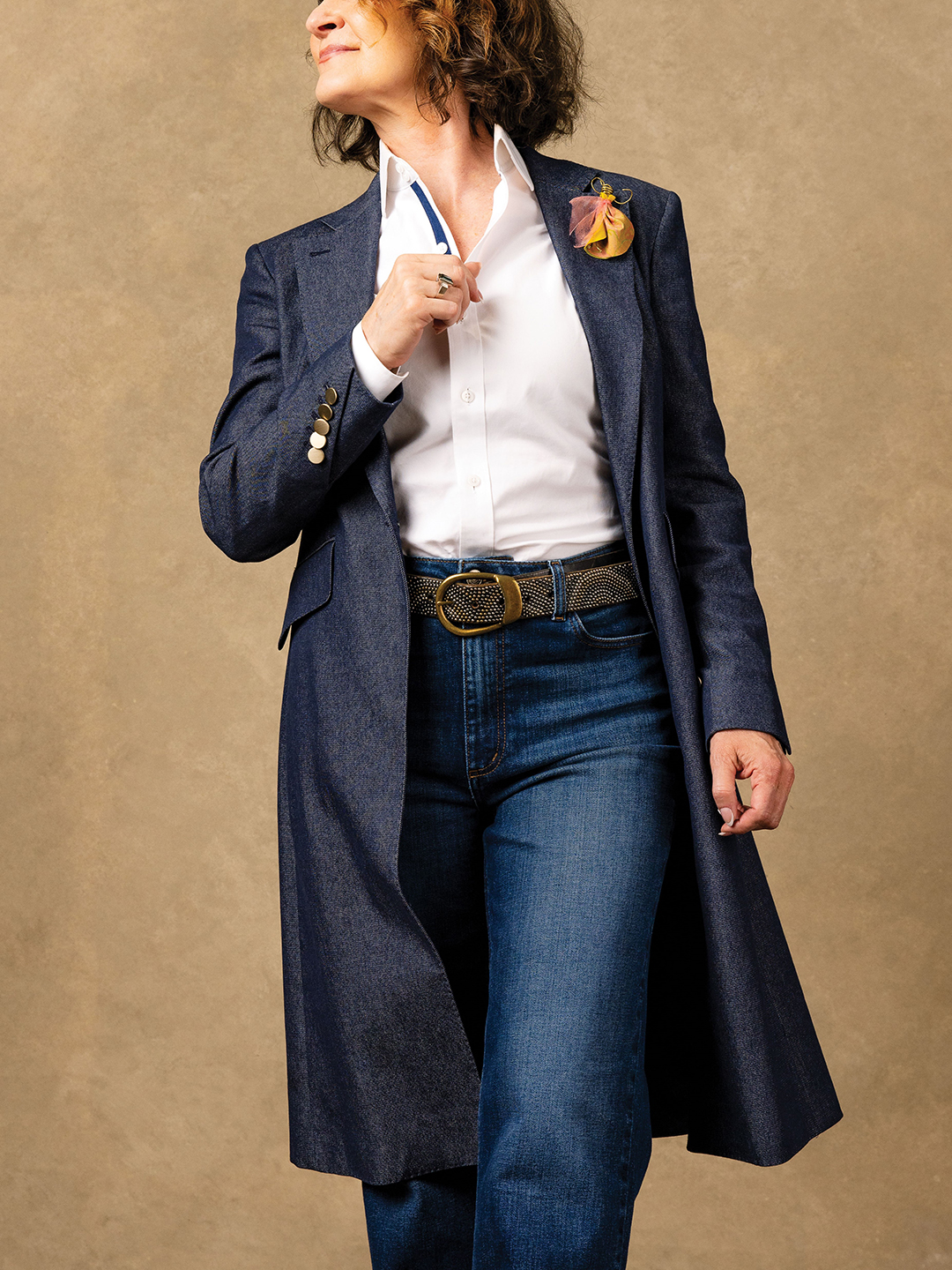 Nice, but Not Too Formal: When Denise McBride wants to command a room without looking too serious, this knee-length De Nimes Duster Coat from Midnight Oil ($795) does the trick. McBride pairs it with the same custom Neems jeans from her Weekend Style look on page 22 and the hardest-working white button-down around from J. Hilburn; the belt is an accessory from her own closet. 