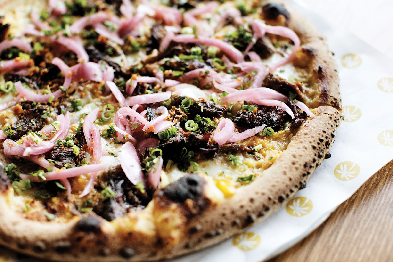 The Show You pizza is topped with braised short ribs, miso corn cream and pickled red onions.